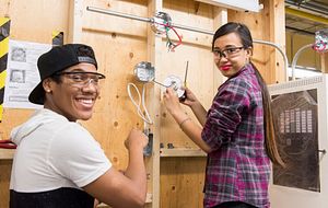 picture of two centennial college electrical engineering students working in a lab with safety equipment